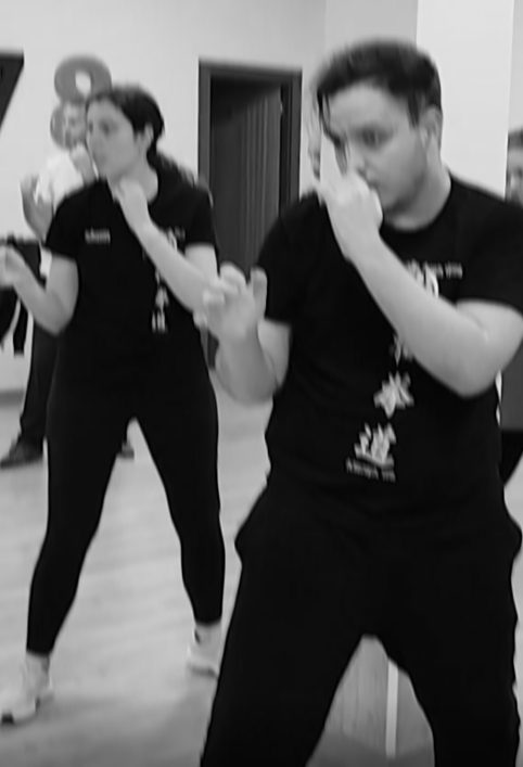 Personas practicando movimientos de defensa personal en un entorno de grupo.